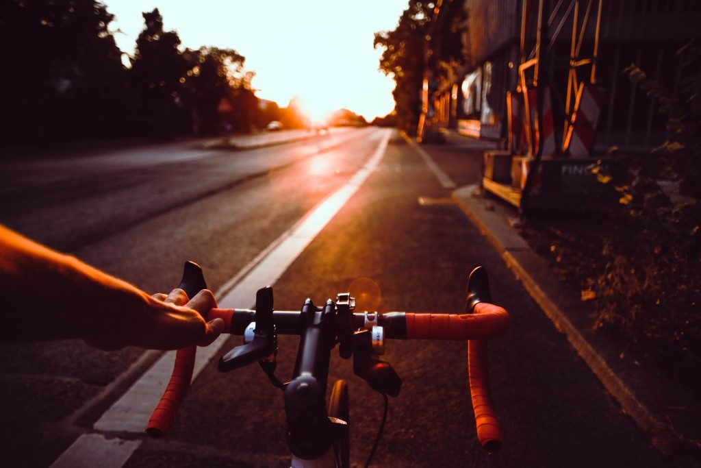 Køretur på racercykel på vej med solnedgang foran